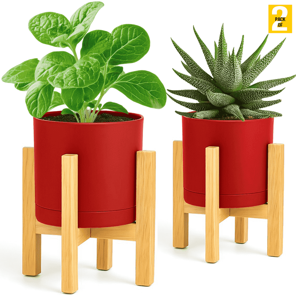 Two red planters with green plants on wooden stands against a white background